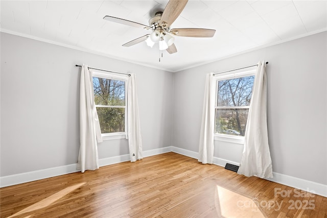 unfurnished room featuring crown molding, plenty of natural light, and light wood-type flooring