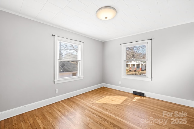 spare room featuring crown molding and wood-type flooring