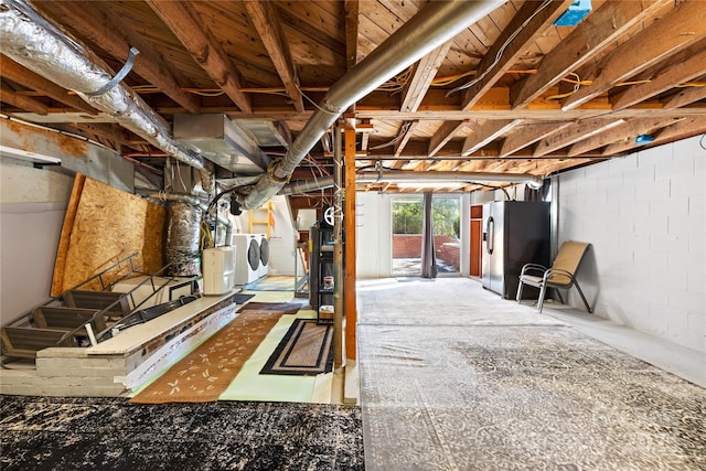 basement with black refrigerator with ice dispenser and washer and dryer