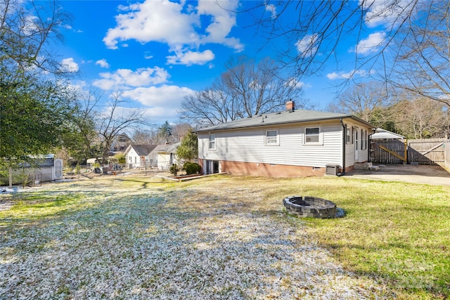 back of house featuring a yard and a fire pit