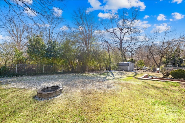 view of yard featuring a shed and an outdoor fire pit