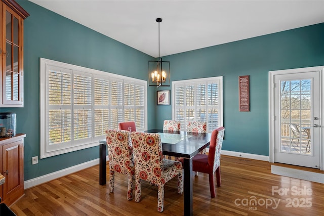 dining room featuring wood-type flooring and an inviting chandelier