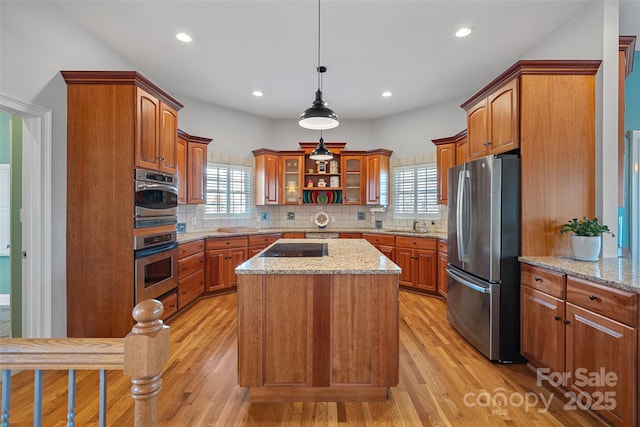 kitchen featuring decorative backsplash, a wealth of natural light, appliances with stainless steel finishes, and a center island