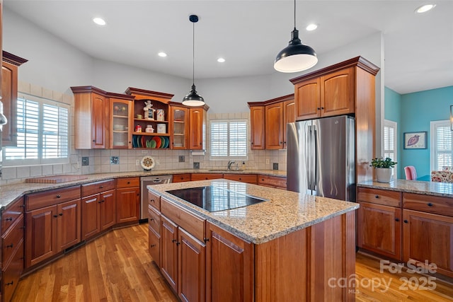 kitchen with stainless steel appliances, decorative backsplash, decorative light fixtures, and a center island