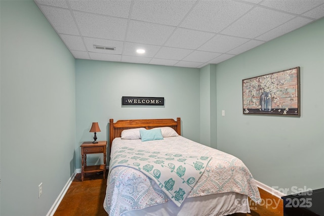 bedroom featuring dark hardwood / wood-style floors and a drop ceiling