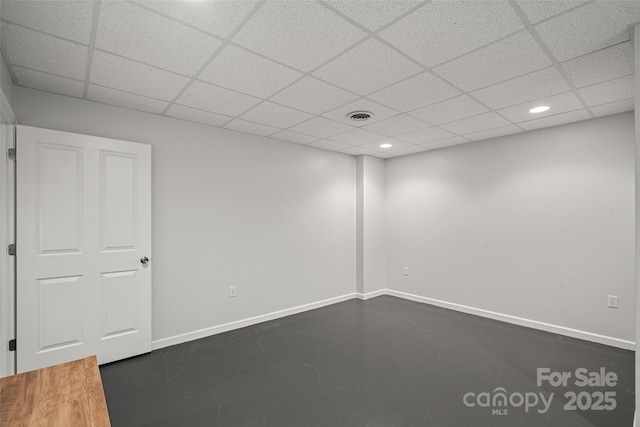 tiled spare room featuring a paneled ceiling