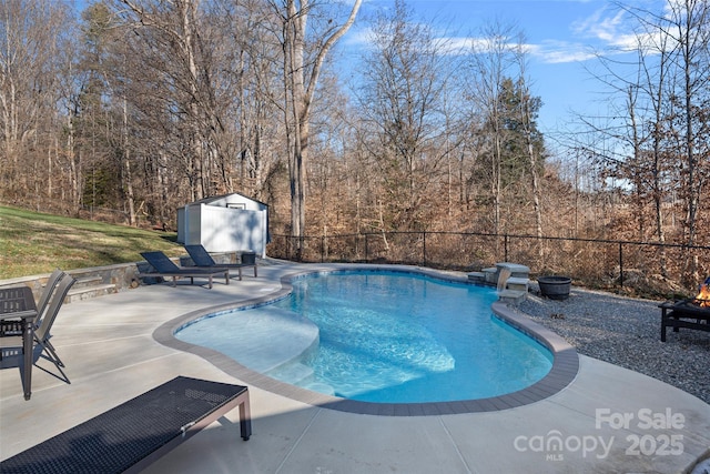 view of pool with a patio area and a shed