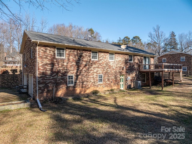 back of property with a lawn, a garage, central air condition unit, and a wooden deck