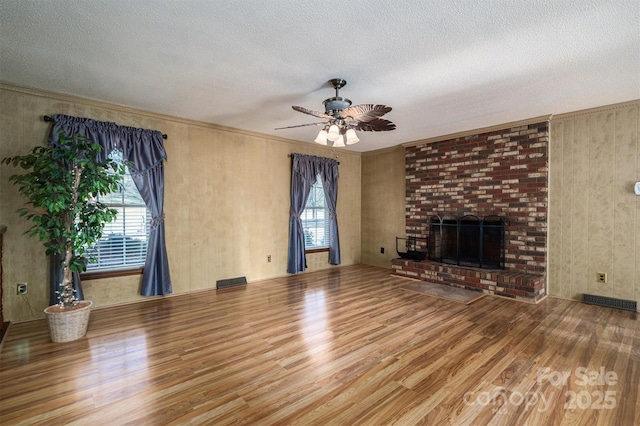 unfurnished living room featuring wood-type flooring, a textured ceiling, and a wealth of natural light