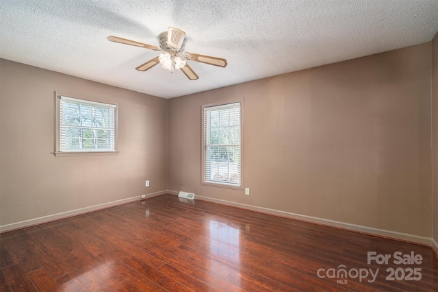 unfurnished room featuring ceiling fan, a textured ceiling, and dark hardwood / wood-style flooring