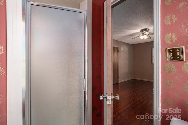 bathroom featuring wood-type flooring, a textured ceiling, walk in shower, and ceiling fan