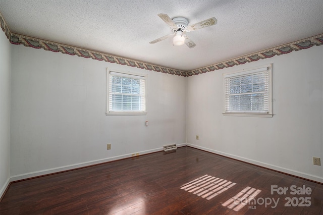 unfurnished room featuring ceiling fan, a textured ceiling, and dark hardwood / wood-style flooring