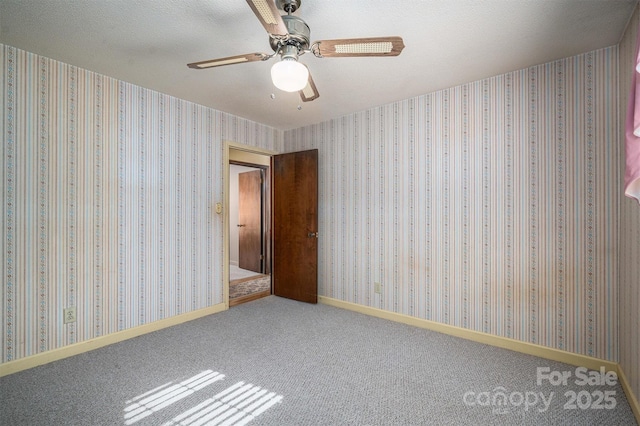 unfurnished room featuring ceiling fan, a textured ceiling, and carpet