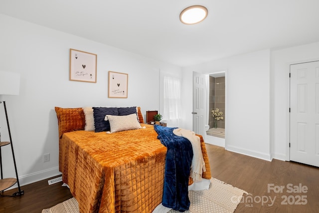 bedroom with dark hardwood / wood-style flooring and ensuite bath