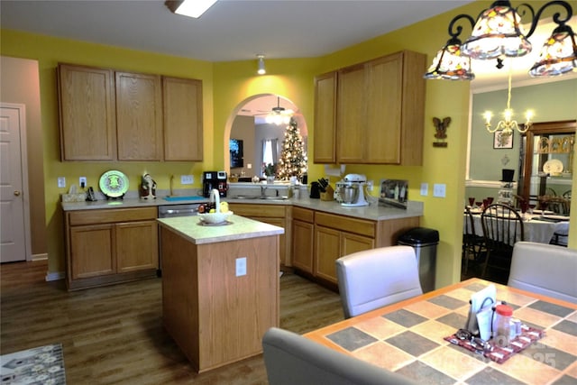 kitchen with a kitchen island, decorative light fixtures, wood-type flooring, an inviting chandelier, and sink