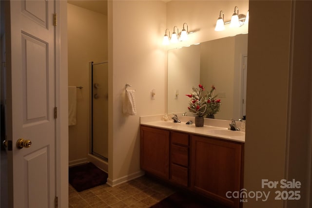 bathroom featuring a shower with shower door and vanity