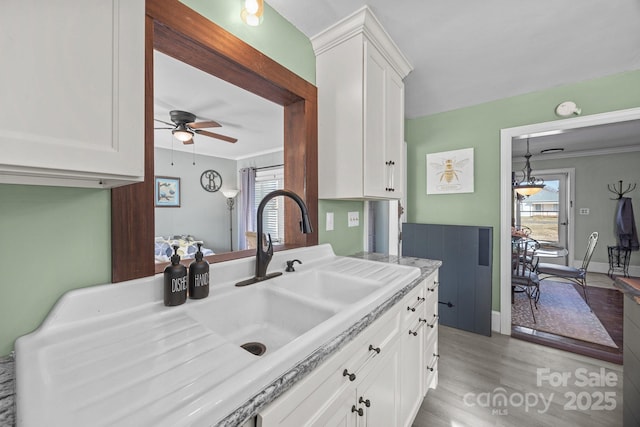 kitchen with sink, ceiling fan, white cabinetry, and plenty of natural light