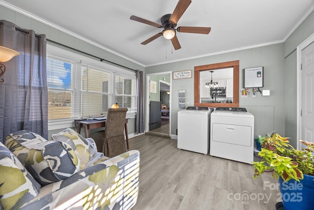 clothes washing area with crown molding, light hardwood / wood-style floors, washer and dryer, and ceiling fan