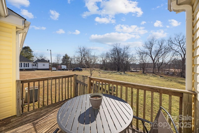 wooden terrace featuring cooling unit and a yard