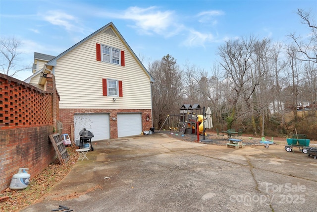 view of side of property featuring a garage and a playground