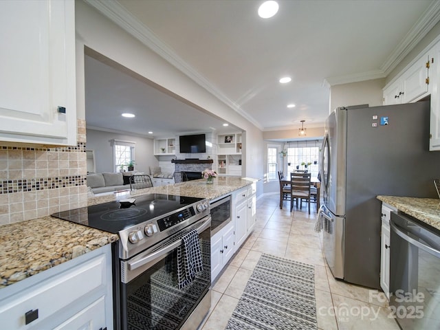 kitchen with light stone countertops, ornamental molding, stainless steel appliances, and white cabinetry