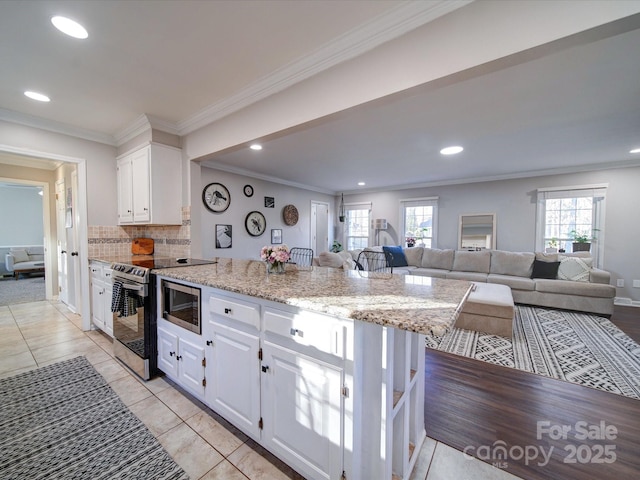 kitchen with white cabinetry, stainless steel appliances, a healthy amount of sunlight, crown molding, and light stone counters