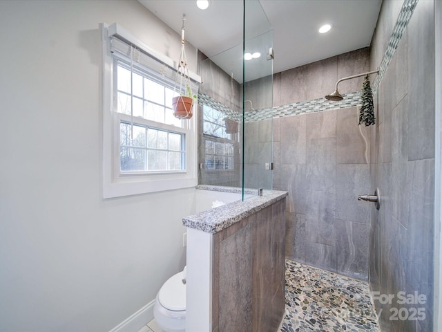 bathroom featuring toilet and a tile shower