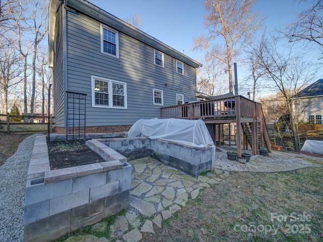 rear view of property with a wooden deck and a patio