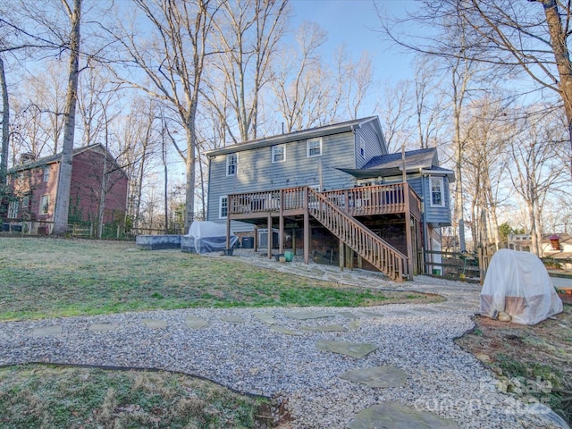 back of house with a wooden deck and a lawn