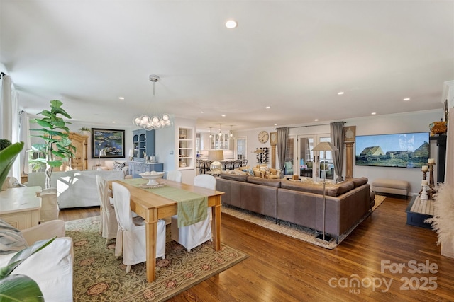 dining room featuring dark hardwood / wood-style floors, crown molding, and a chandelier