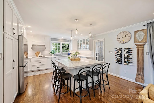 dining room featuring sink, dark hardwood / wood-style floors, and crown molding