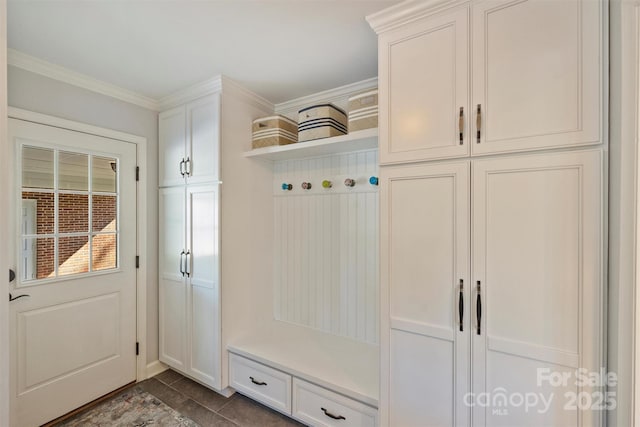 mudroom featuring dark tile patterned floors and ornamental molding