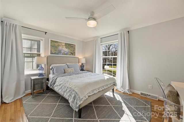 bedroom featuring ceiling fan, hardwood / wood-style floors, and crown molding