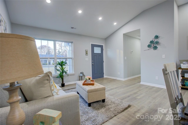 living room featuring vaulted ceiling and light wood-type flooring