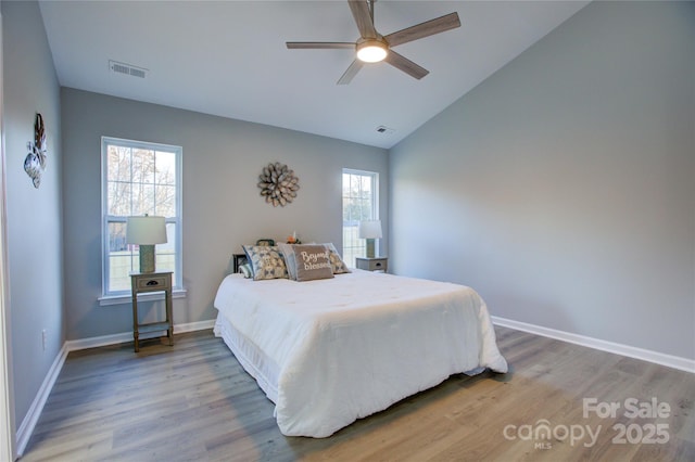 bedroom with ceiling fan, lofted ceiling, hardwood / wood-style floors, and multiple windows