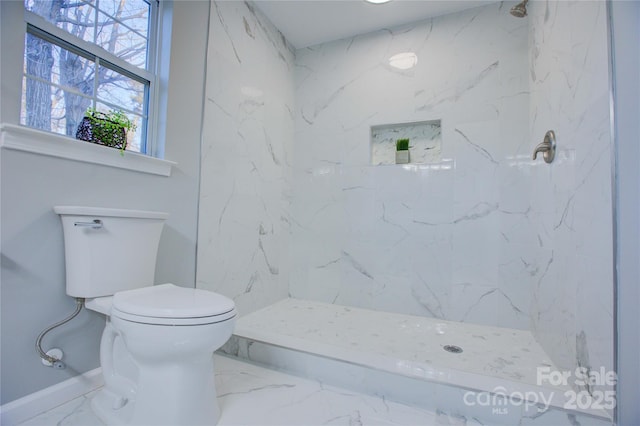 bathroom featuring toilet and a tile shower