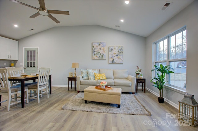 living room featuring ceiling fan, a wealth of natural light, light hardwood / wood-style flooring, and lofted ceiling