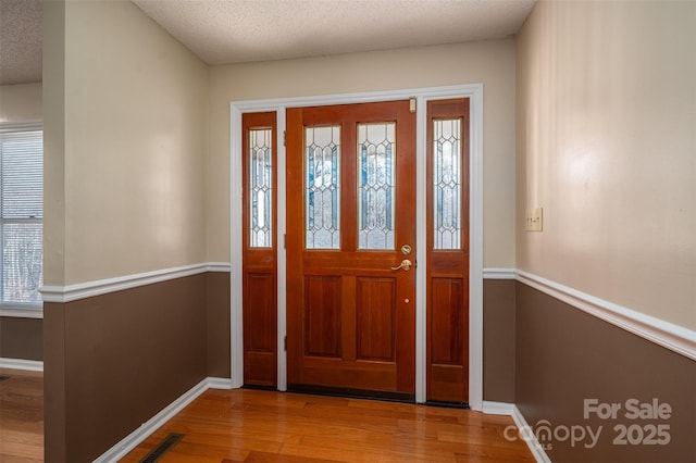 entrance foyer featuring light hardwood / wood-style floors and a textured ceiling