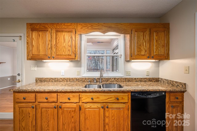 kitchen featuring wood-type flooring, stone countertops, dishwasher, a textured ceiling, and sink