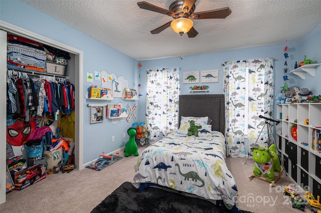 bedroom with ceiling fan, carpet, a textured ceiling, and a closet