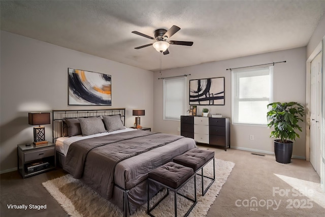 carpeted bedroom with ceiling fan and a textured ceiling