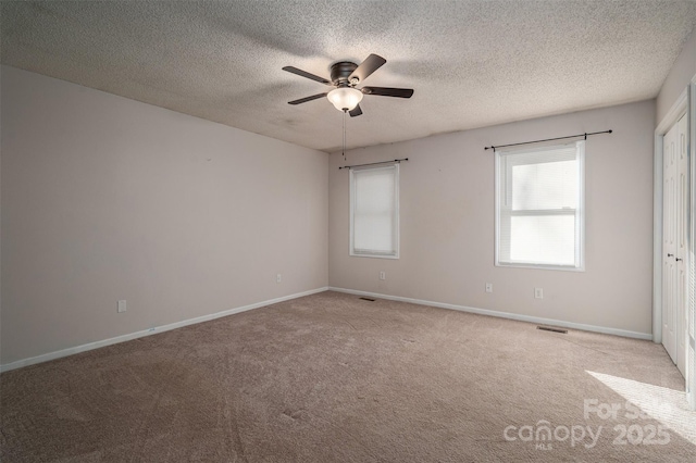 empty room with a textured ceiling, light carpet, and ceiling fan