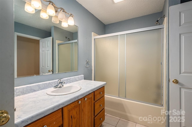 bathroom featuring tile patterned floors, vanity, bath / shower combo with glass door, and a textured ceiling