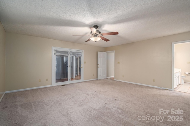 unfurnished room with a textured ceiling, ceiling fan, and light colored carpet