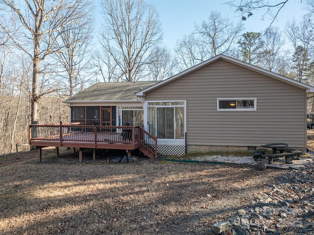 rear view of property featuring a sunroom and a wooden deck