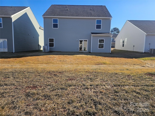 back of property with cooling unit and a yard