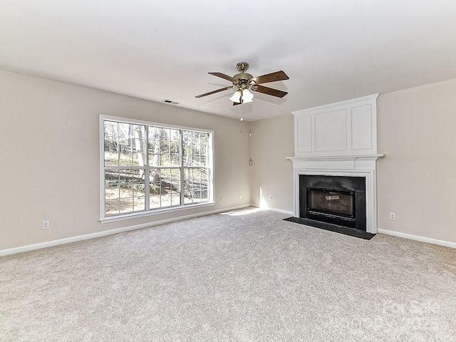 unfurnished living room featuring light carpet, ceiling fan, and a fireplace