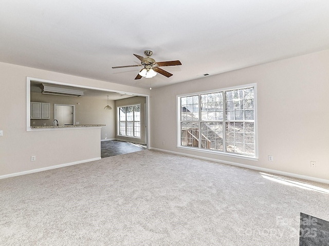 unfurnished living room with ceiling fan and carpet