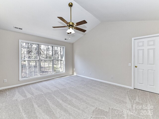 carpeted empty room with ceiling fan and vaulted ceiling