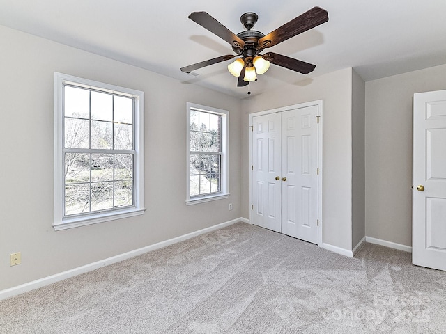 unfurnished bedroom with ceiling fan, light carpet, and a closet